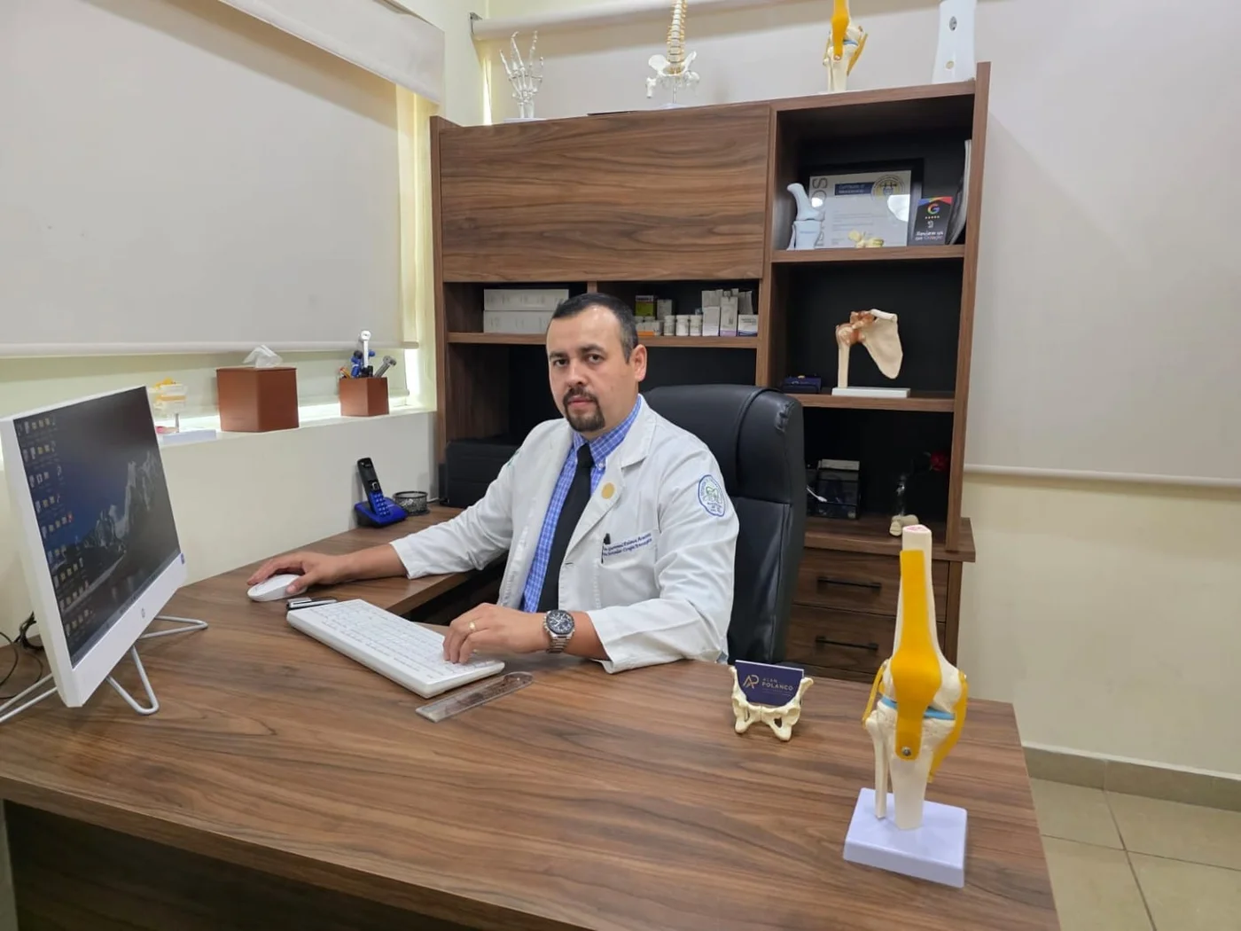 El Dr. Alan Polanco en el escritorio de su consultorio de ortopedia.